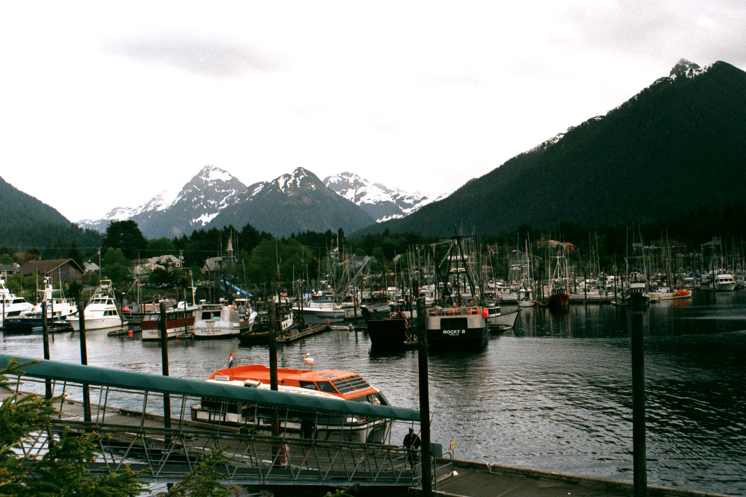 Fishing boats in Sitka Harbor beneath snow-streaked mountains